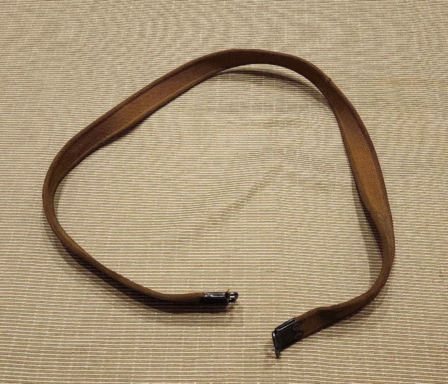 Full length view of 1942 Enfield khaki web sling with blackened brass hooks at each end