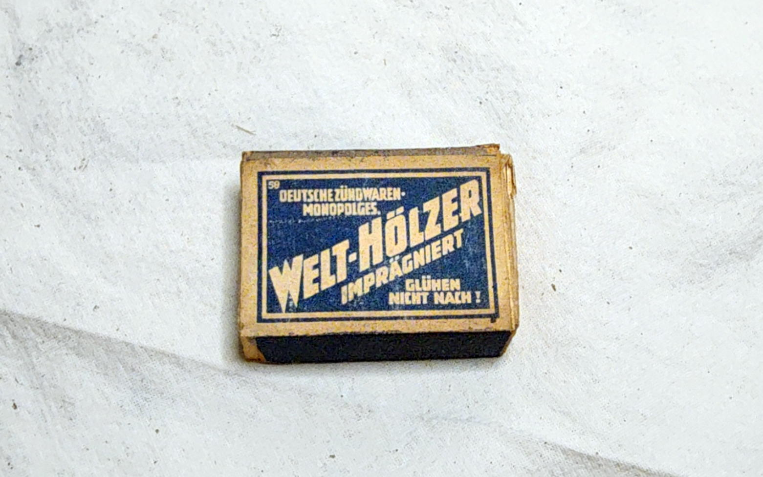 Blue and cream Welt-Hölzer matchbox label with diagonal lettering and small corner number 59