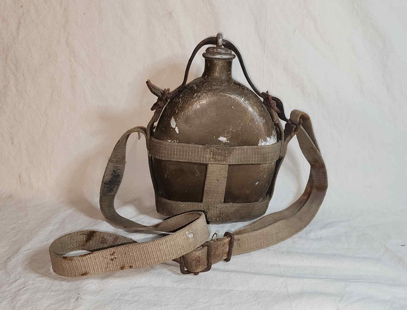 Reverse view of a 1940 Imperial Japanese Army Sho-5 I-go canteen showing the carrier and shoulder strap hardware