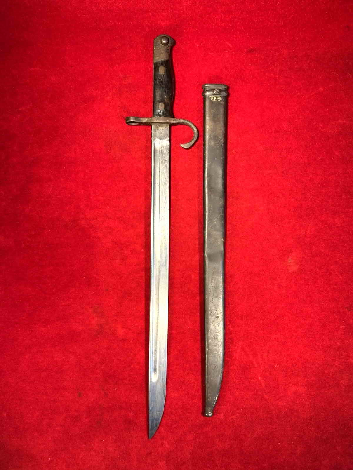 Imperial Japanese Type 30 service bayonet displayed beside its steel scabbard