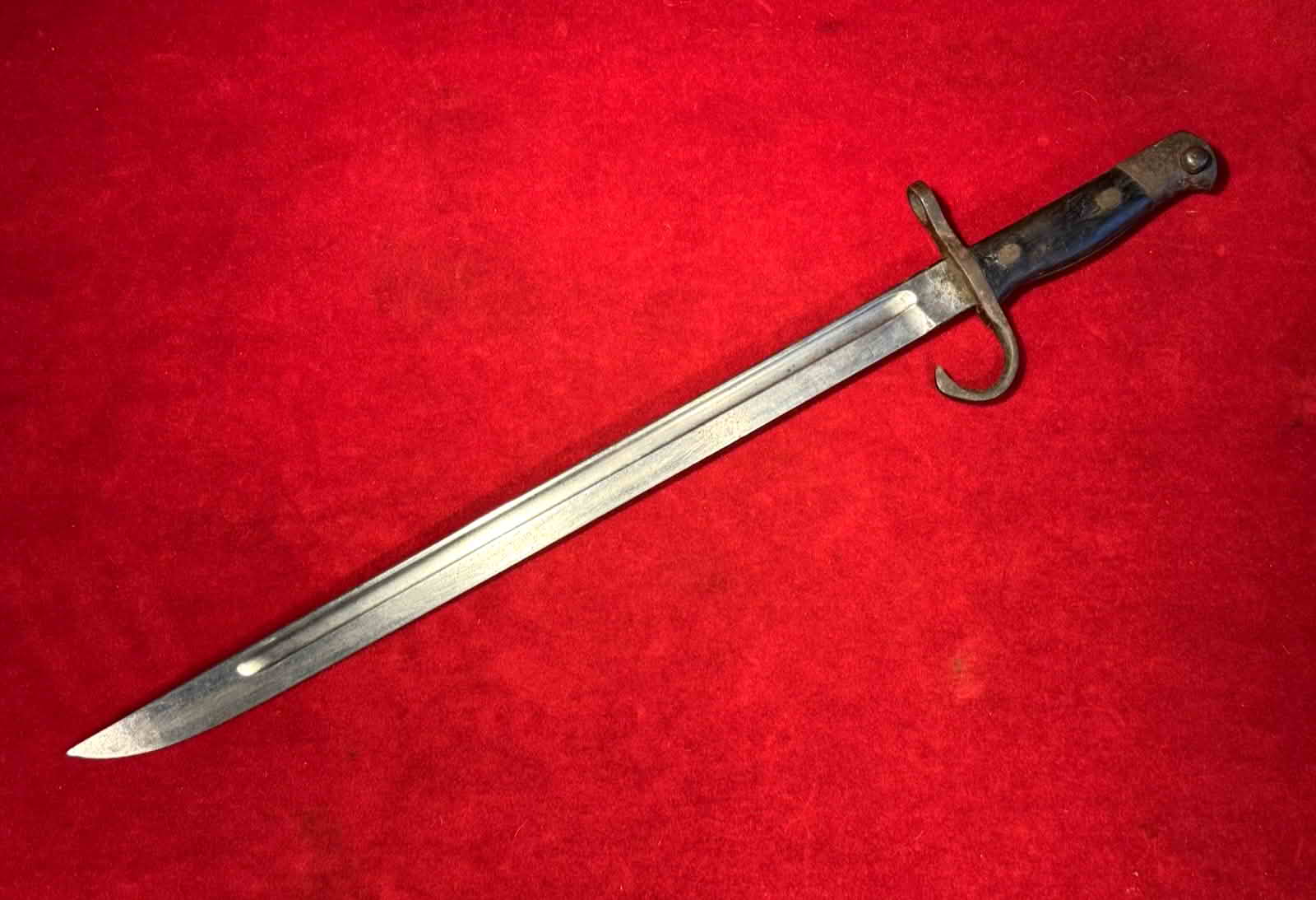 Full view of the Japanese Type 30 bayonet showing its bright fullered blade and hooked quillon