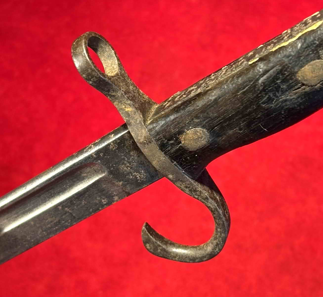 Angled view of the Type 30 bayonet crossguard, grip fasteners, and fullered blade