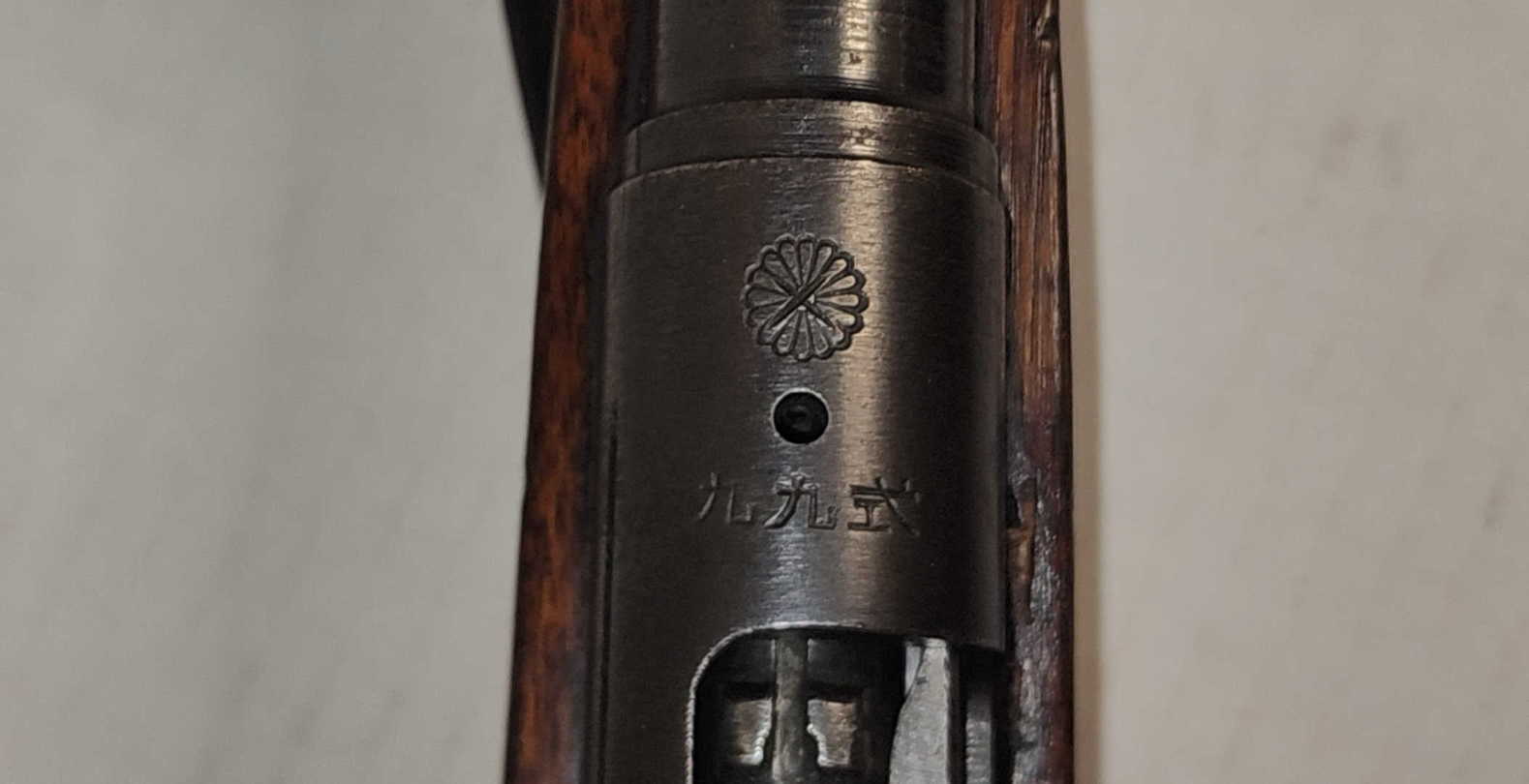 Imperial chrysanthemum crest on the receiver ring, with a visible impact cross on the crest