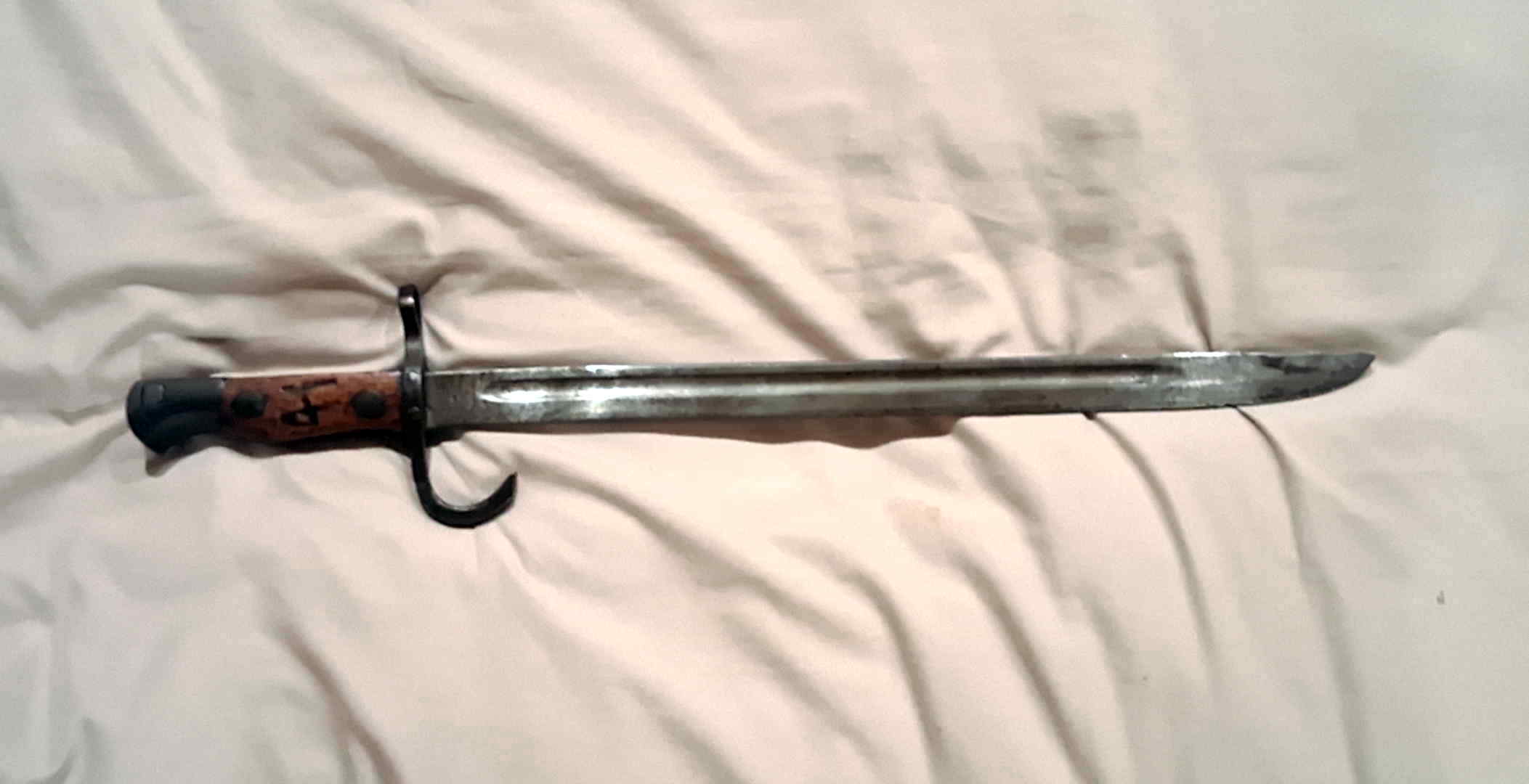 Full view of the Japanese Type 30-pattern school bayonet showing its hooked quillon and irregular fuller