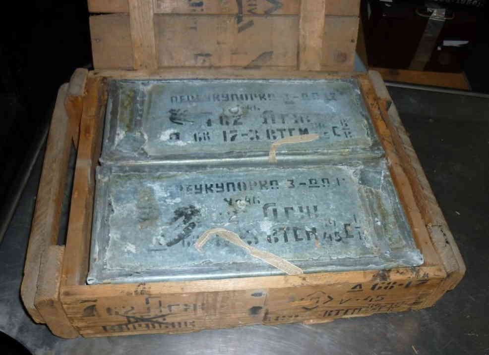 Opened wooden crate showing two hermetically sealed 7.62mm spam cans with Cyrillic stenciling