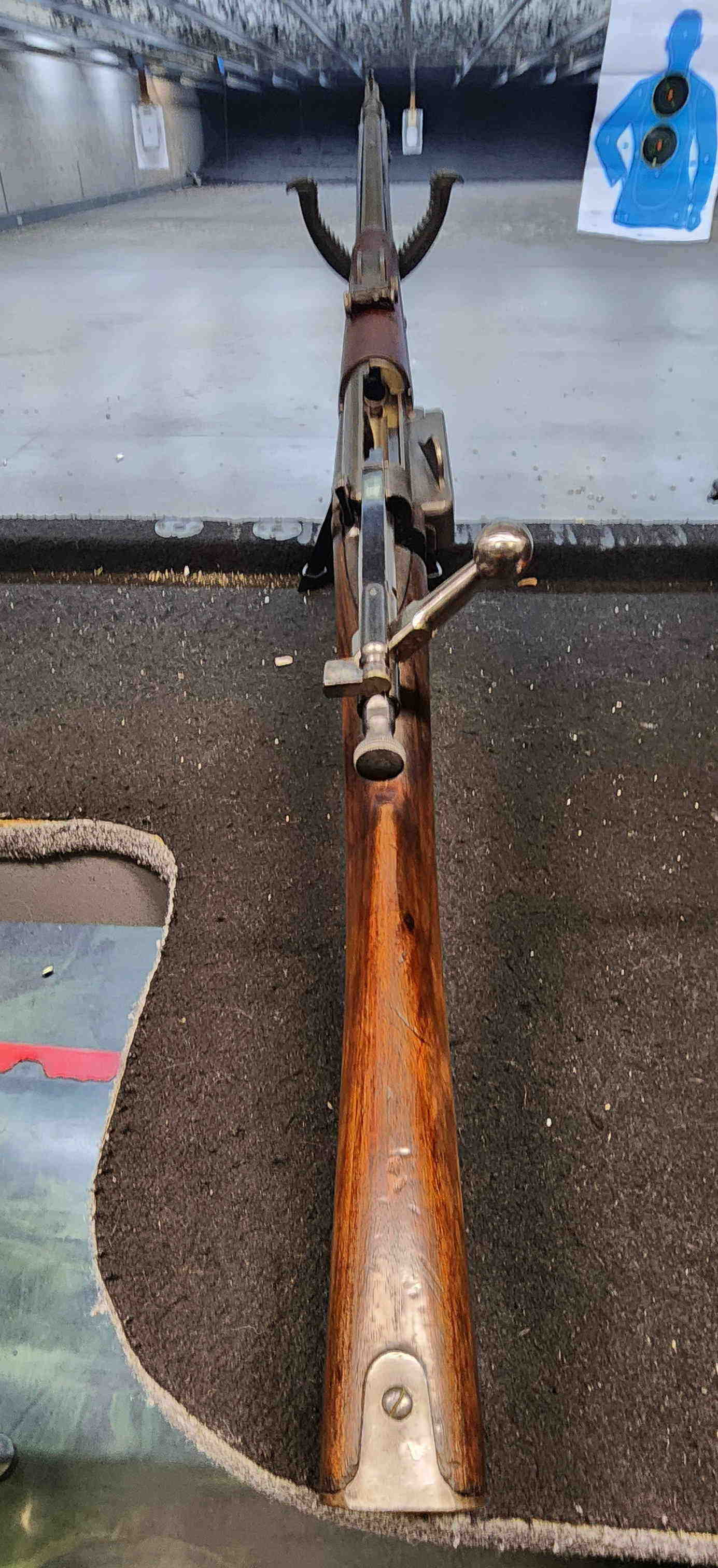 Krag rifle aligned downrange at indoor range, bolt open