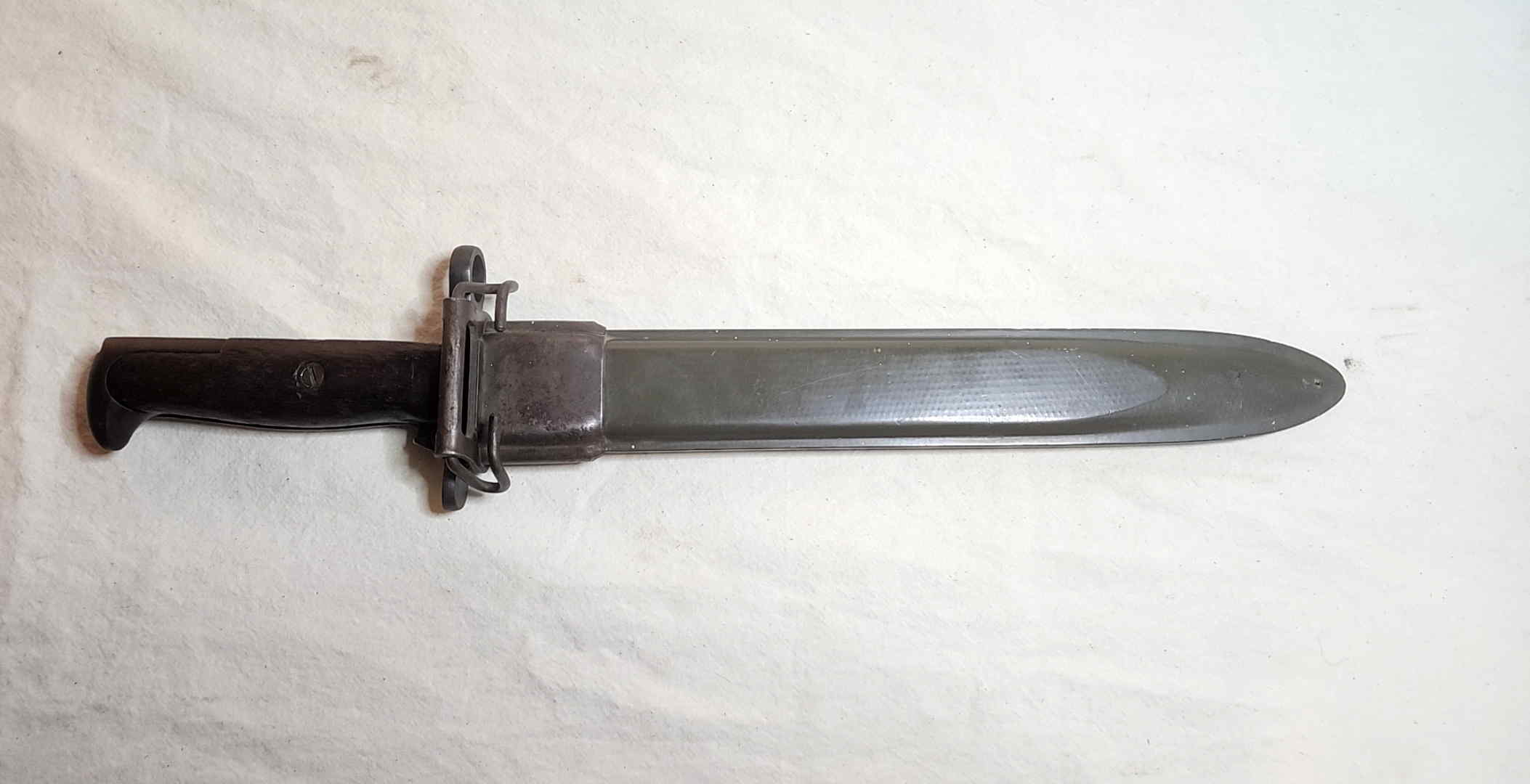 Reverse view of the olive-drab fiberglass scabbard and its M1910-pattern wire belt hanger