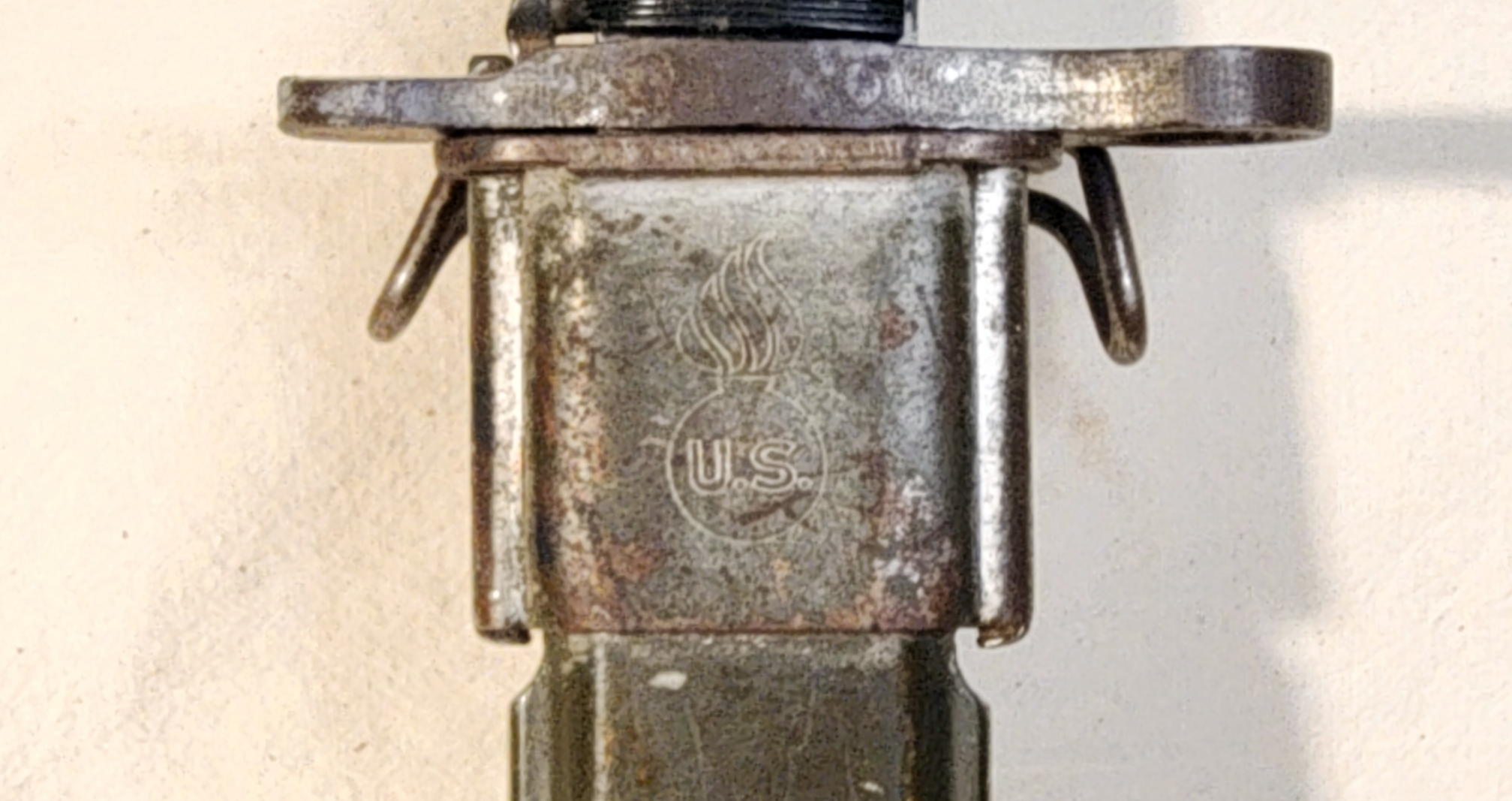 Close view of the U.S. Ordnance shell-and-flame mark on the scabbard's steel throat