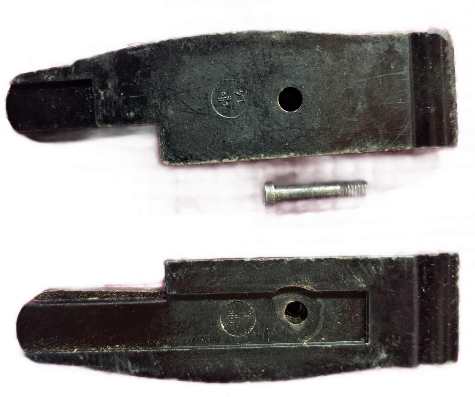 Removed grooved grip panels and fastener showing their molded marks on the underside